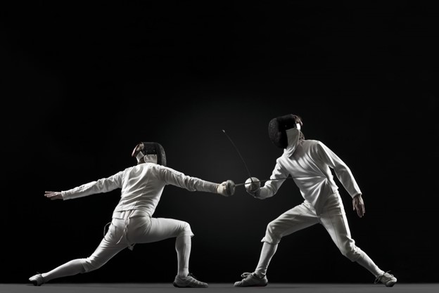 Two fencers dressed in white on a black background, one lunging the other parrying.